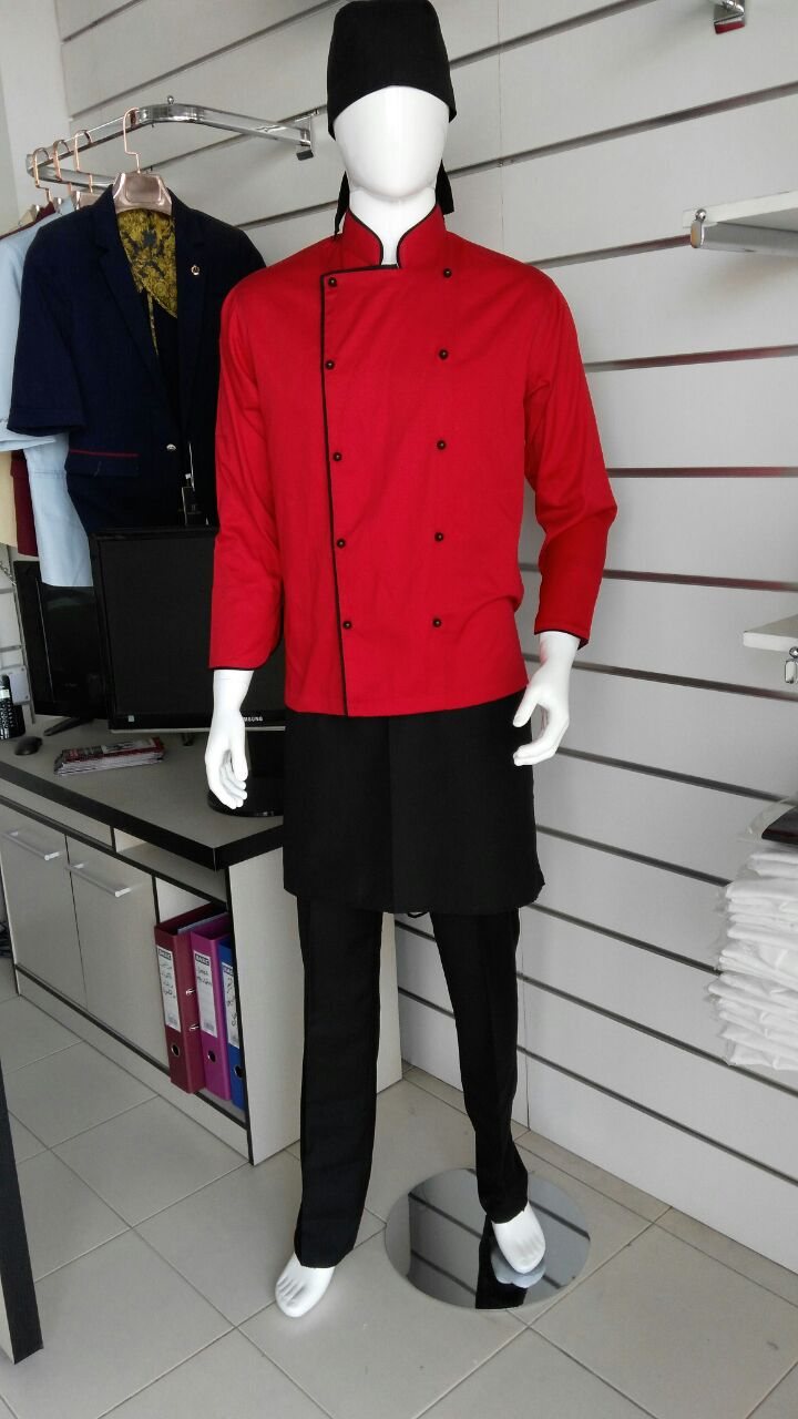 Red chef jacket with black buttons, black trousers and a black chef hat on a mannequin in a showroom