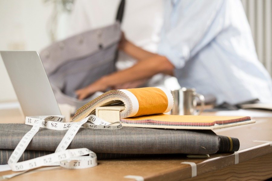 Tape measure, fabric pieces and papers on a tailor's work table